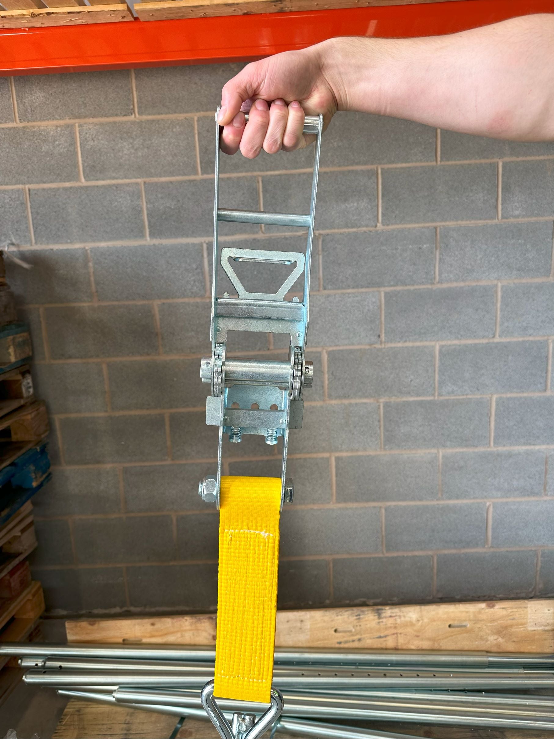 10,000kg Ratchet Strap with Claw Hooks, 10 Metres, held in hand, showcasing robust metal ratchet tensioner, ideal for securing large industrial machinery.