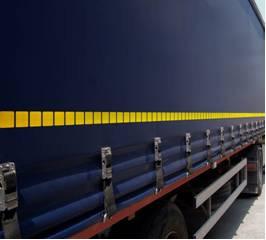 Close-up of a blue truck showcasing the WHITE Segmented Conspicuity Tape, 50 Metre Roll, ideal for enhancing visibility on commercial trailers and vehicles.